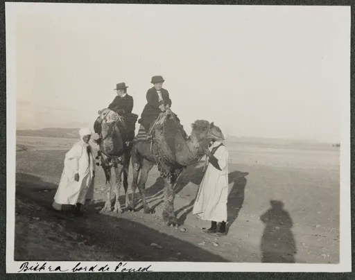 Ottilie W. Roederstein und Jeanne Smith auf Kamelen mit einheimischen Begleitern, Biskra, Bord de l'Oued