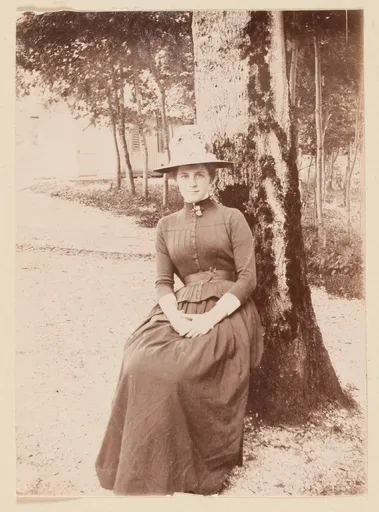 Frau, bei einem Baum sitzend