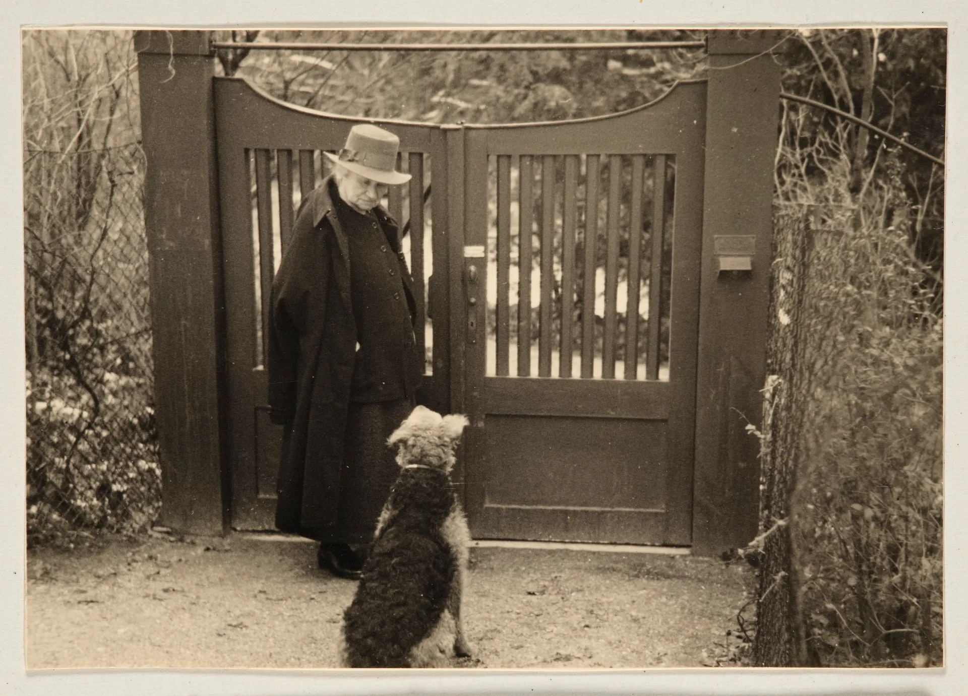 Ottilie W. Roederstein mit ihrem Hund vor einem Tor, Hofheim am Taunus